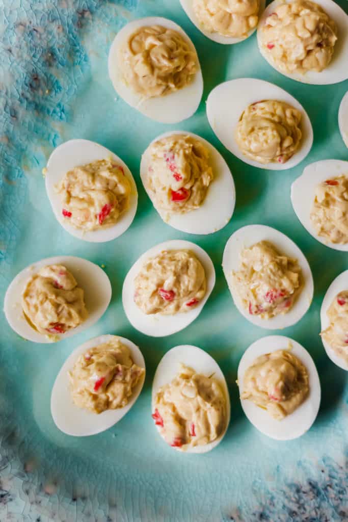 deviled eggs with pimento cheese on a green platter