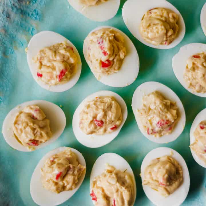 deviled eggs with pimento cheese on a green platter