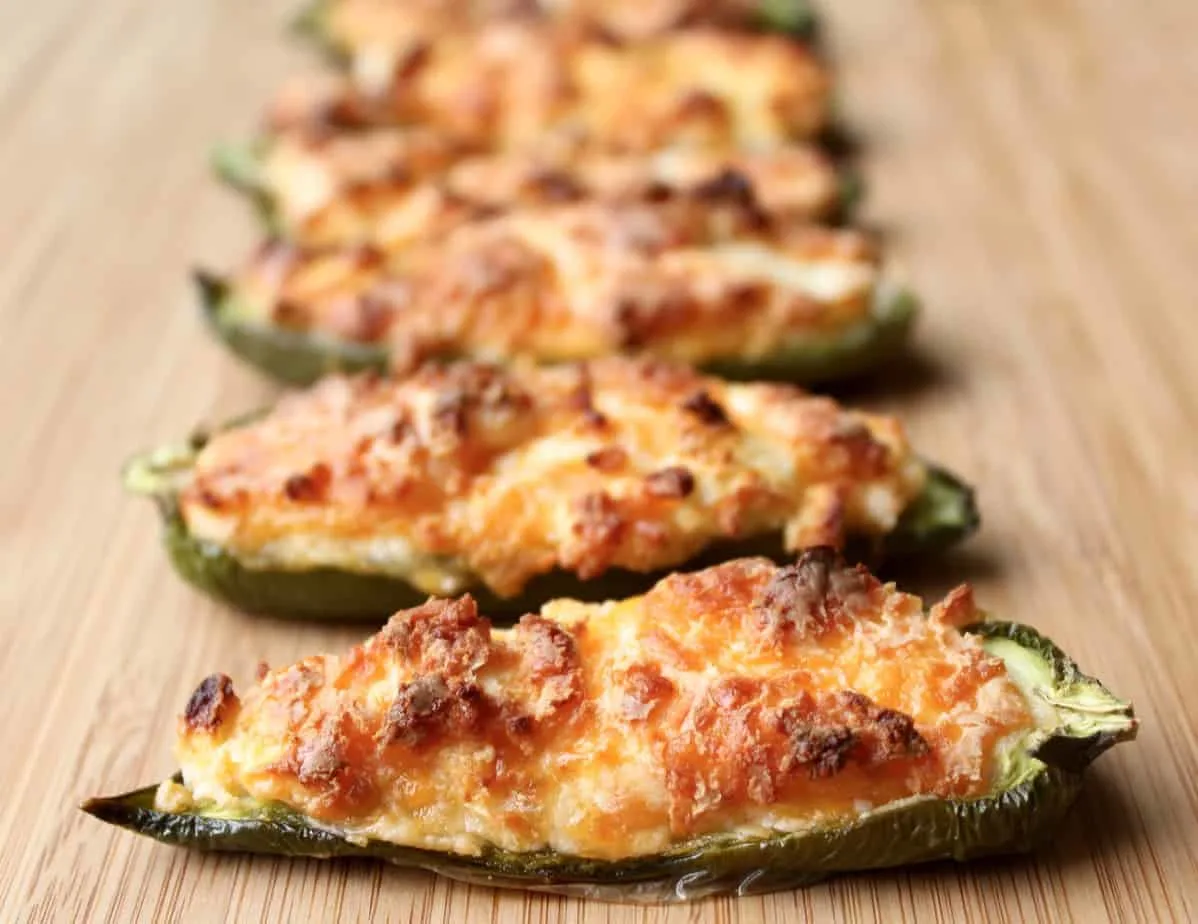 green halved baked jalapenos stuffed with brown melted cheese green halved baked jalapenos stuffed with brown melted cheese