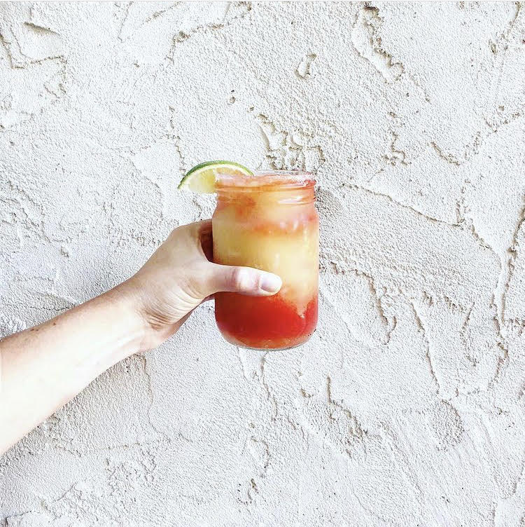 colorful margarita in front of a textured white wall