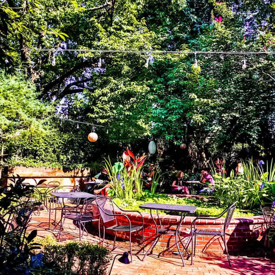 tables in front of a koi pond with big trees and cafe lights on the patio at dilworth tasting room-2