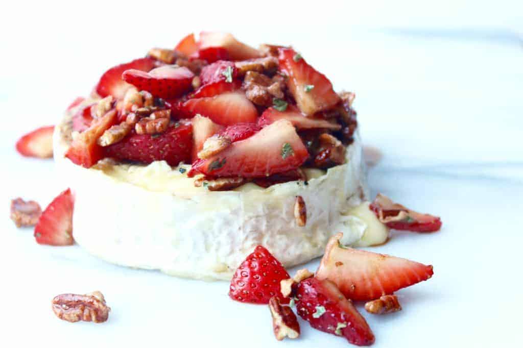 easy brie appetizer with strawberries and pecans on a white background