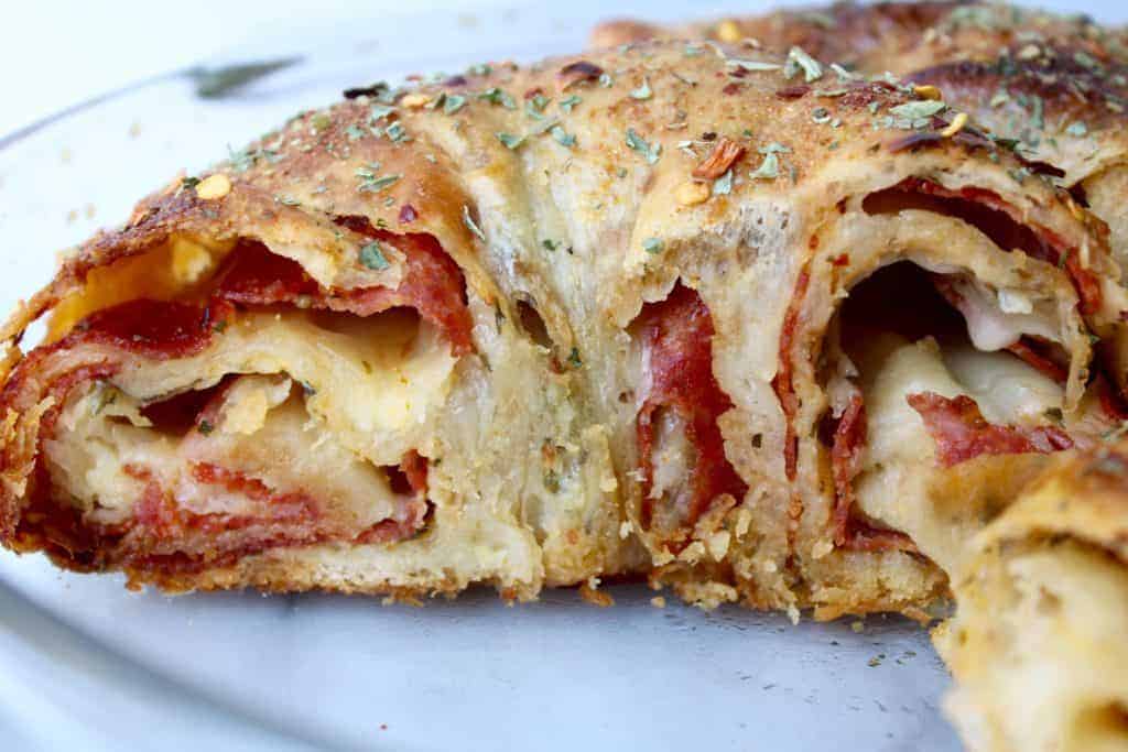 pepperoni stuffed bread with cheese and spices in a glass pie plate