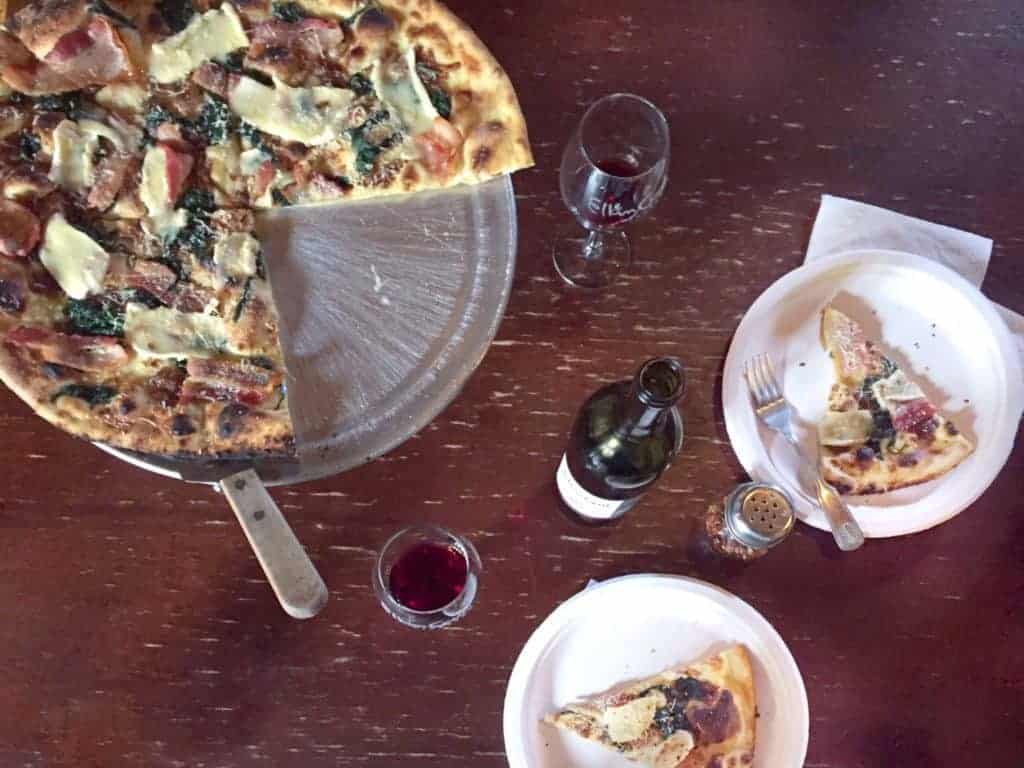 a bottle of wine and large pizza at elkin creek winery