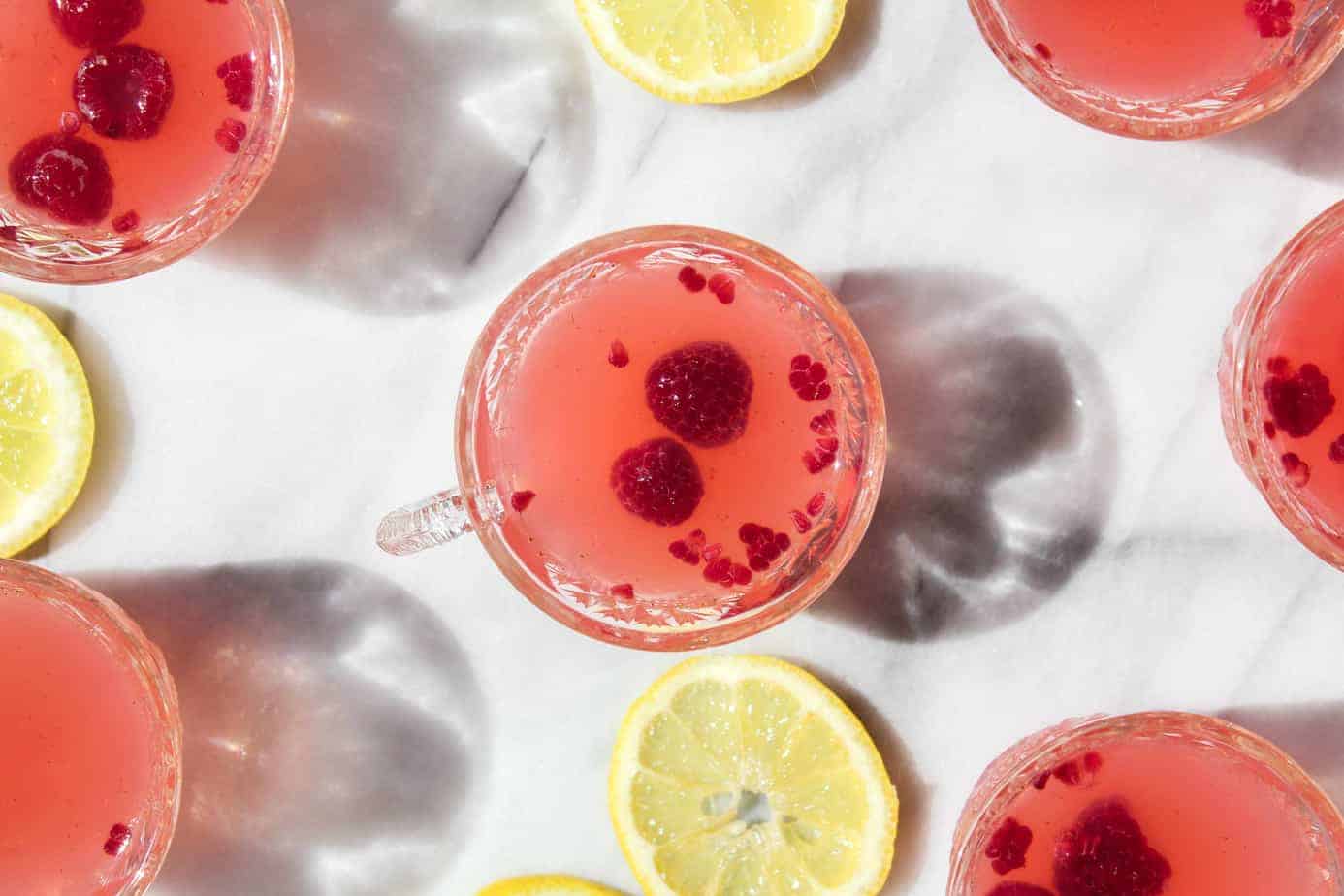 baby shower pink punch served in small glass cups with handles and slices of lemons