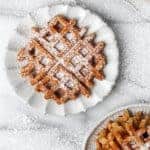 pumpkin waffles on plates with powdered sugar