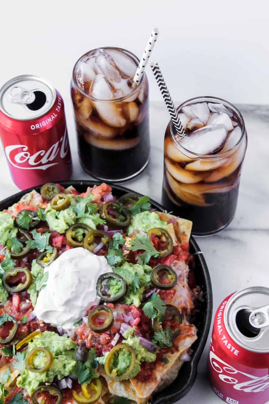 loaded grilled nachos with ice cold coke with straws