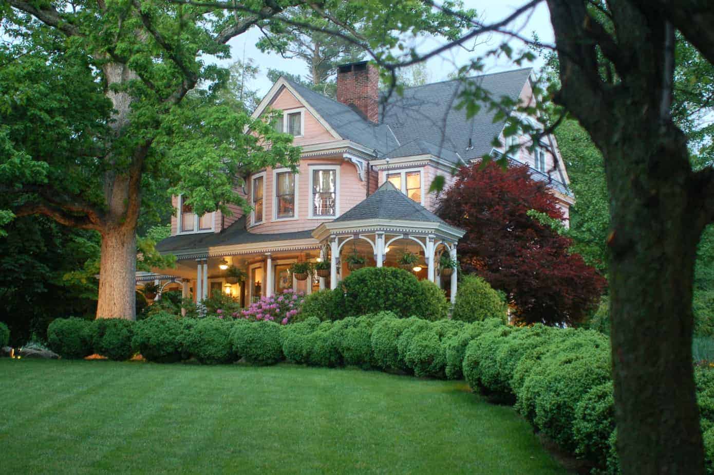 lush lawn and bushes line the driveway to the pink house at Beaufort Inn and Asheville NC B&B