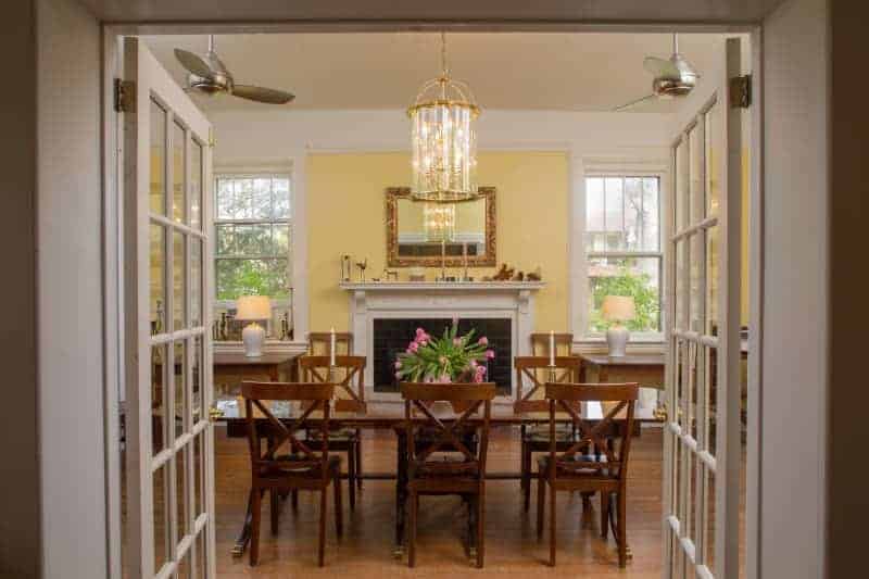 dining room with wood table and chairs with fresh flowers and chandelier at an asheville bed and breakfast