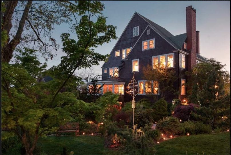 front of the whitegate inn a bed and breakfast near asheville, nc at dusk with the inside illuminated 