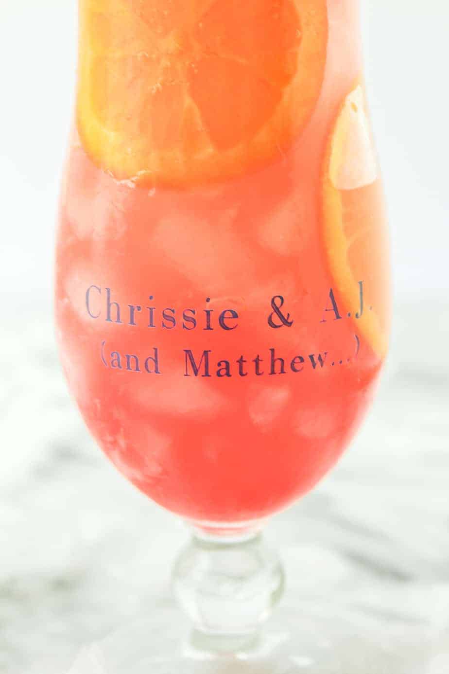 personalized hurricane drink glasses filled with hurricane cocktails and orange slices