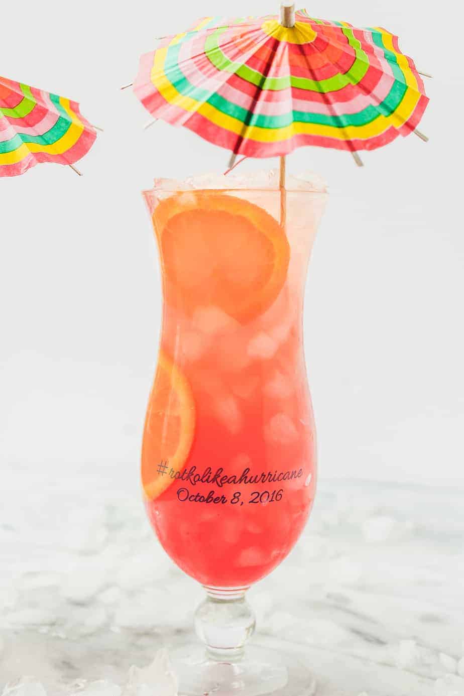 personalized hurricane glasses filled with an easy hurricane drink recipe