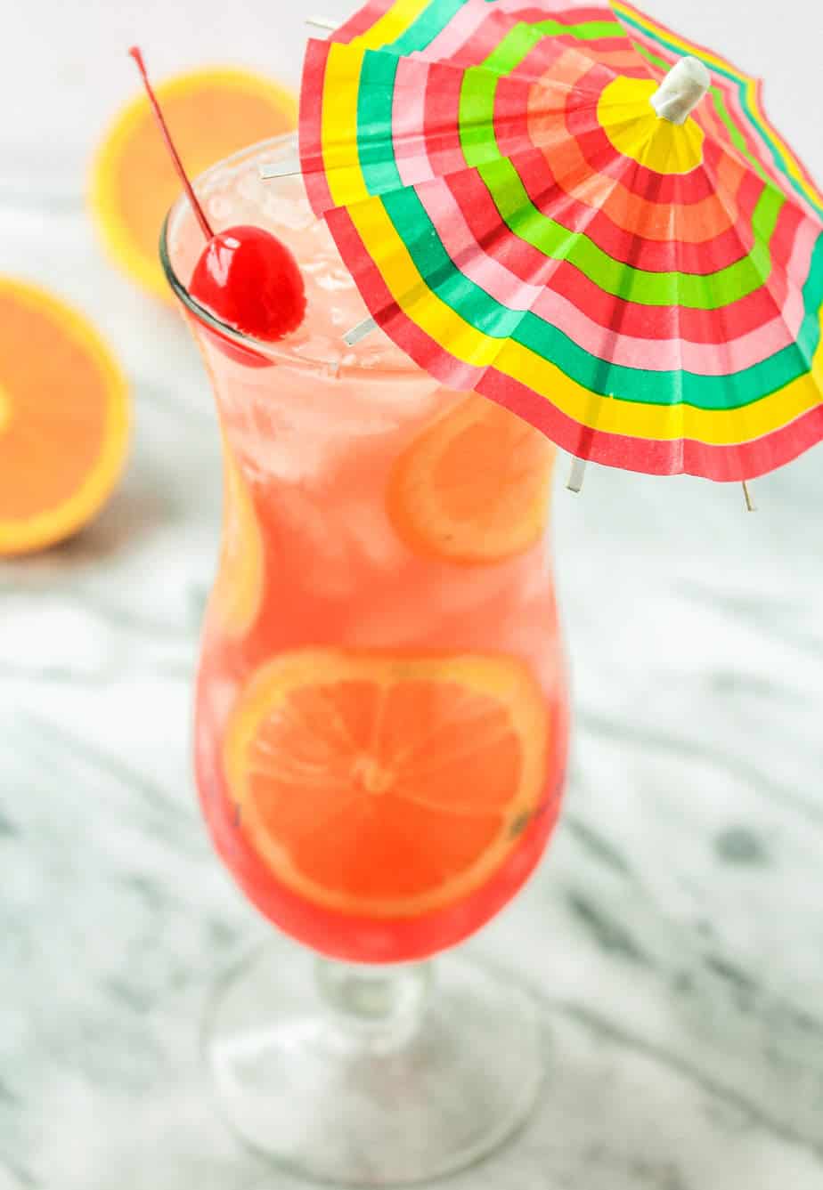 easy hurricane drink recipe with passion fruit juice, orange julce, lime, grenadine and rum garnished with orange slices and a cherry