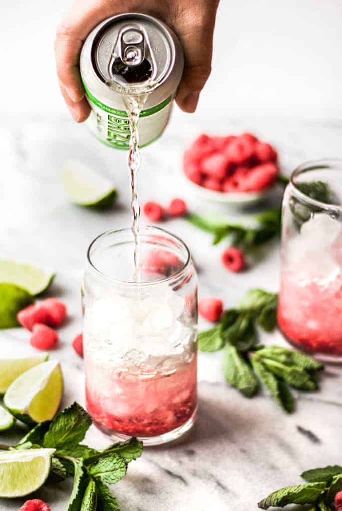 ginger lime brizo being poured into raspberry gin seltzer cocktails