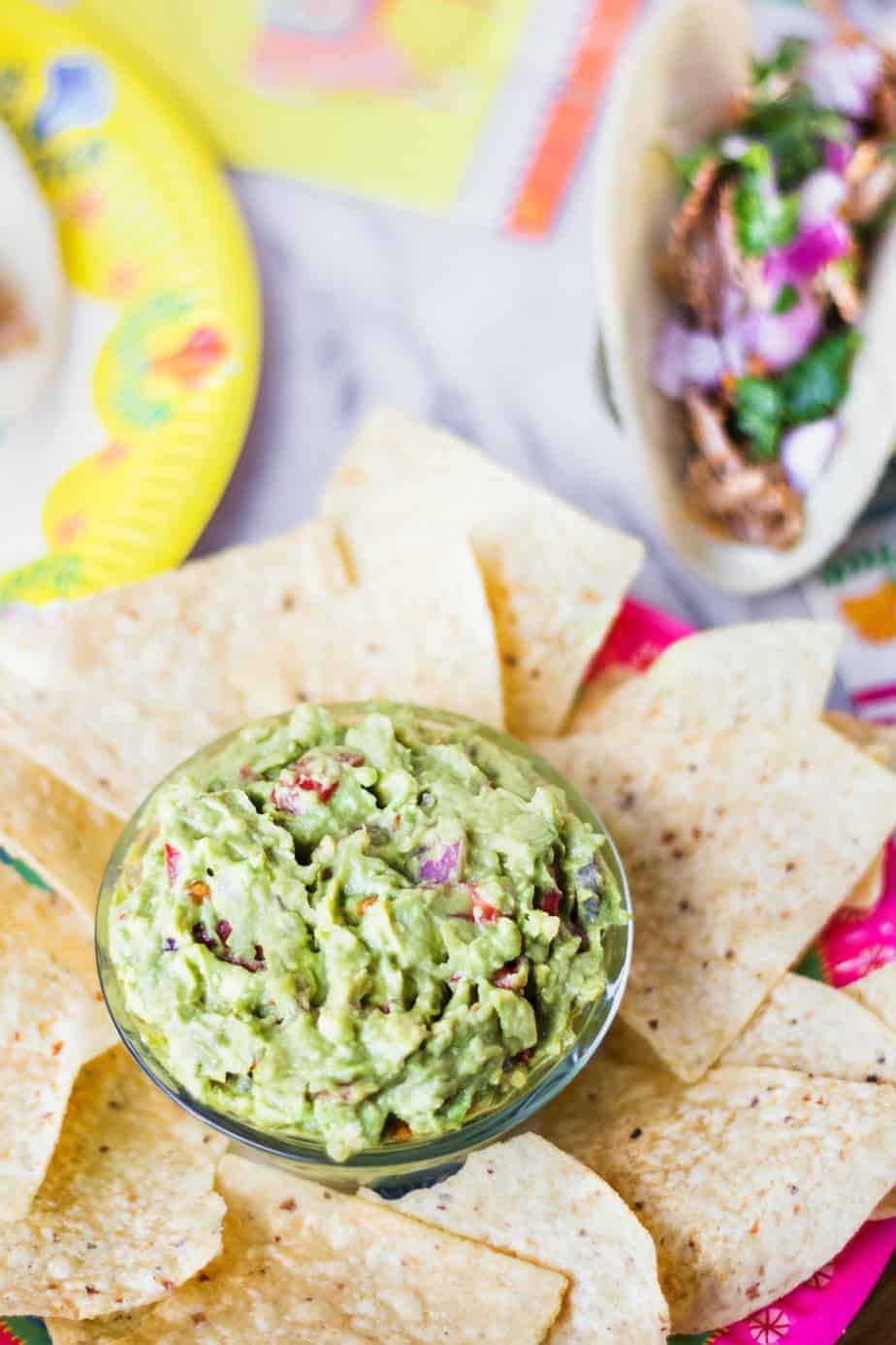 homemade guacamole surrounded by chips for a taco bar party