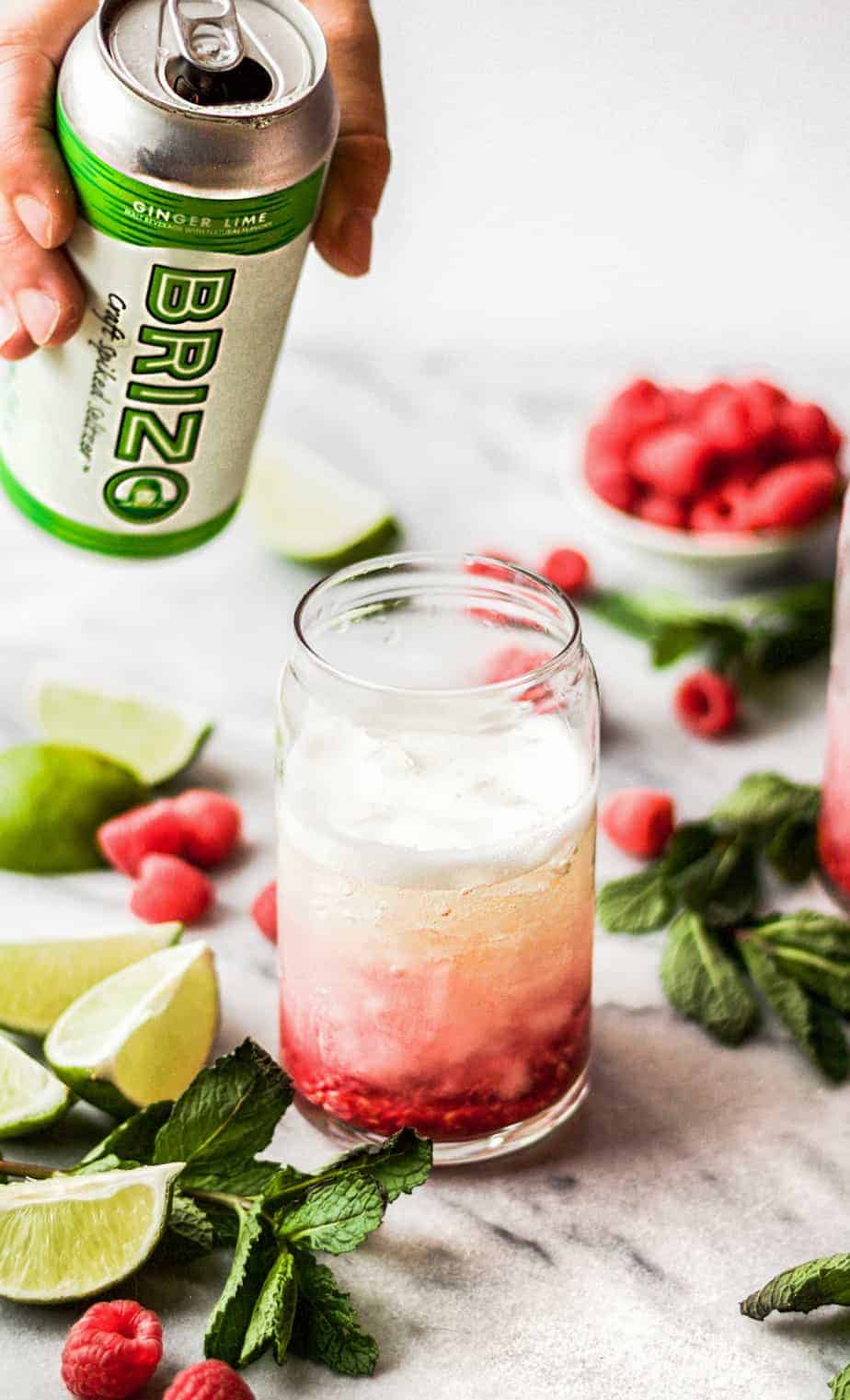 pouring a can of brizo into raspberry gin seltzer drink Off the Eaten