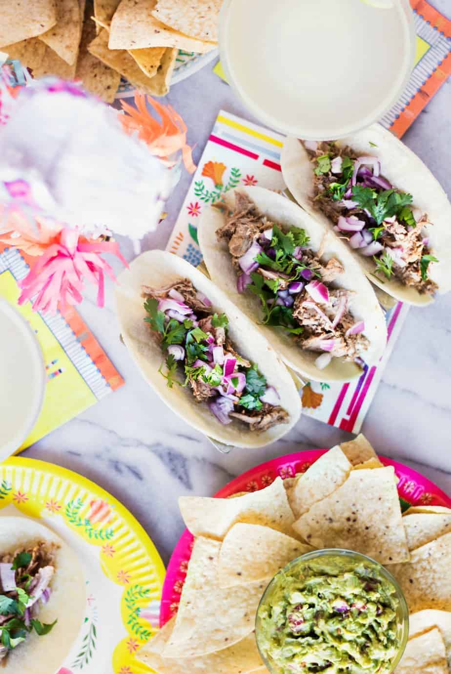 three pork carnitas tacos with red onion and cilantro