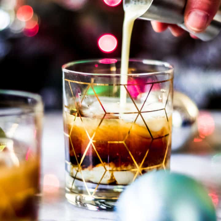 pouring eggnog into a christmas white russian cocktail