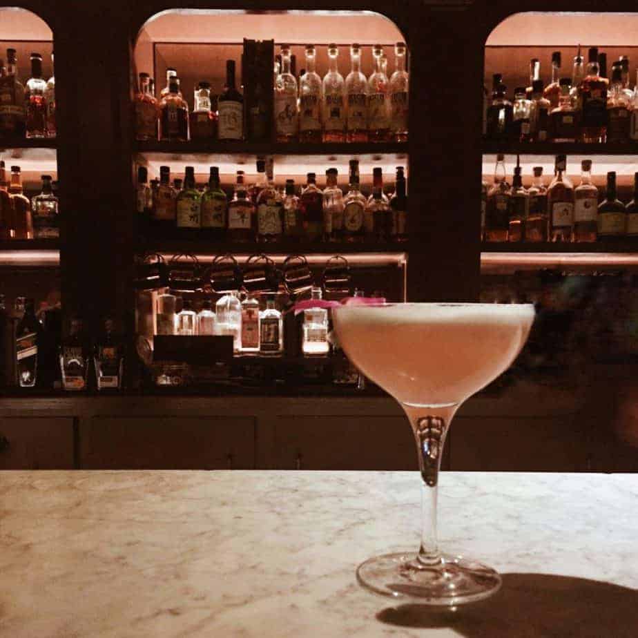 pink-cocktail-in-front-of-a-bar-of-alcohol