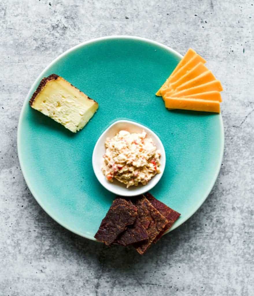 teal plate with cheddar cheese, pimento cheese and beef jerky