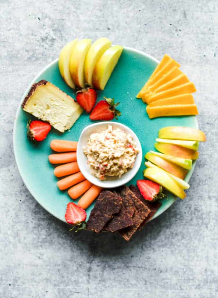 teal plate with cheddar cheese, pimento cheese and beef jerky and strawberries