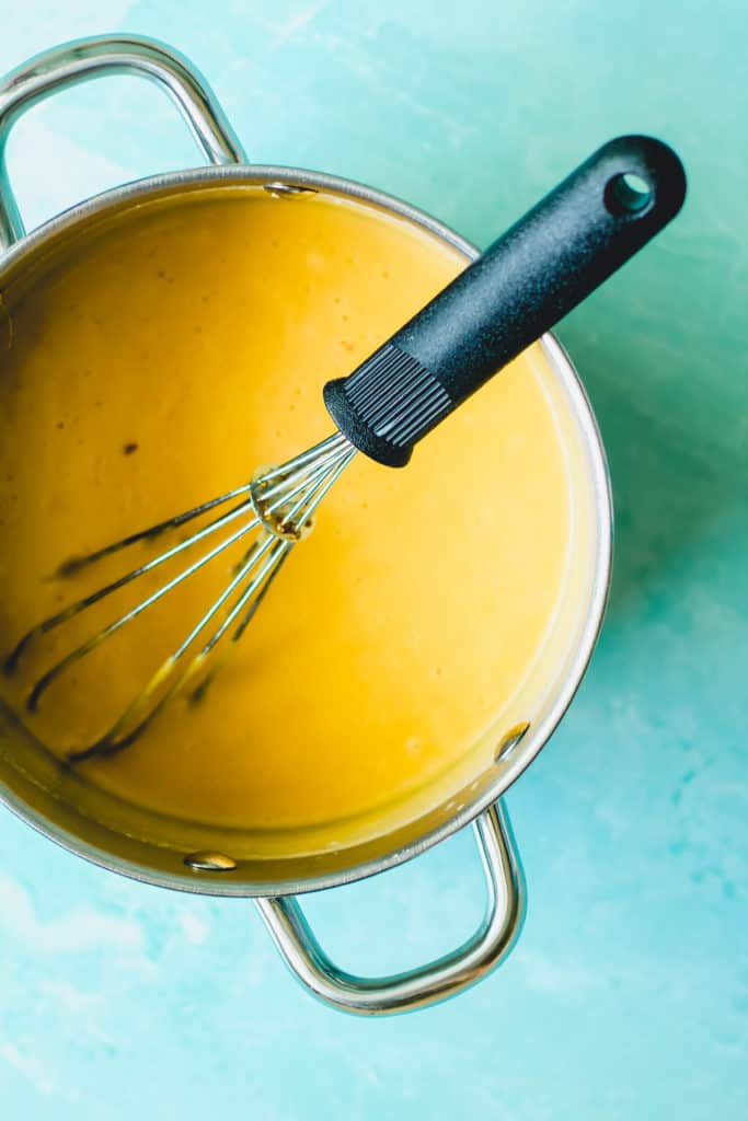 beer cheese sauce in a pot with a whisk