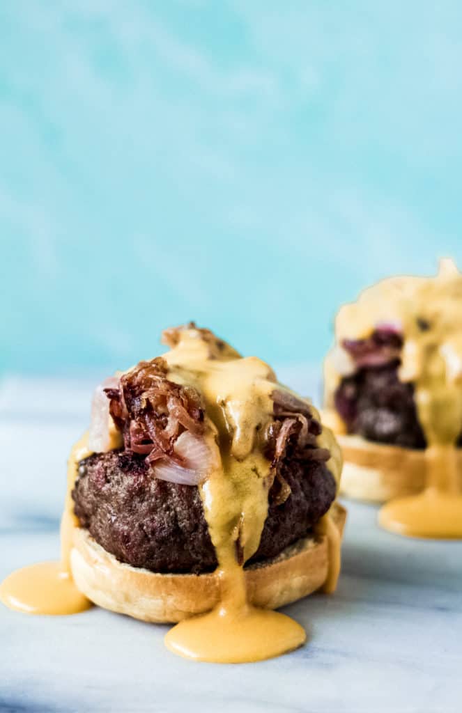 brat burgers topped with caramelized onions and beer cheese sauce