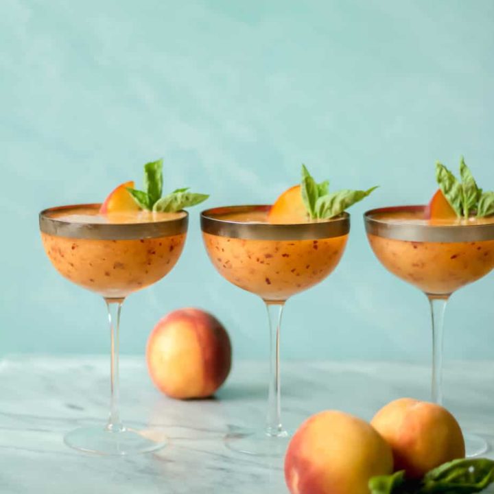 three cocktail glasses filled with drinks against a blue background