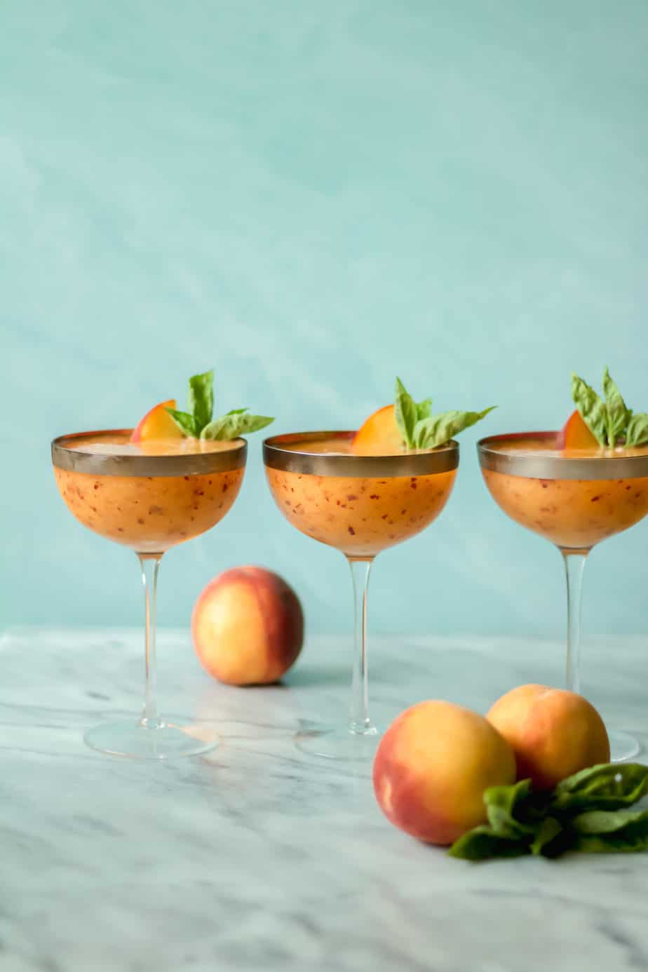three cocktail glasses filled with drinks against a blue background