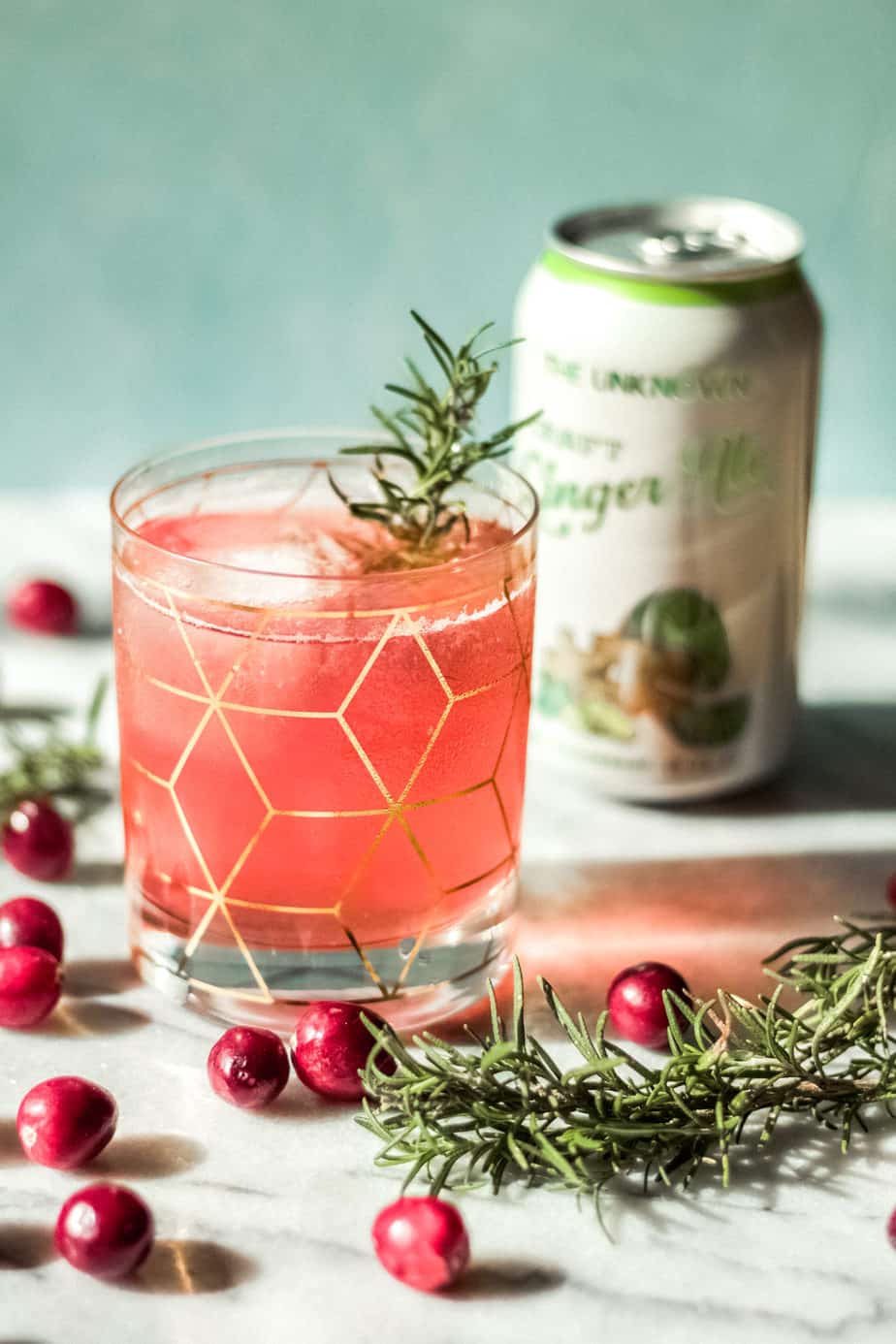 cocktail glass with gold design with can of ginger ale in the background