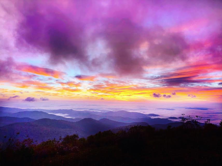 pink, purple, blue and orange sunrise with fog on the mountains at sunrise at black balsam knob hike north carolina