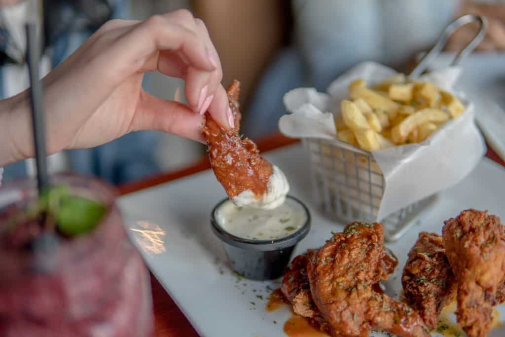 dipping a Buffalo wing into ranch or blue cheese