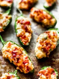 jalapeno pepper halves stuffed with pimento cheese and bacon on a metal sheet tray
