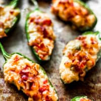 jalapeno pepper halves stuffed with pimento cheese and bacon on a metal sheet tray