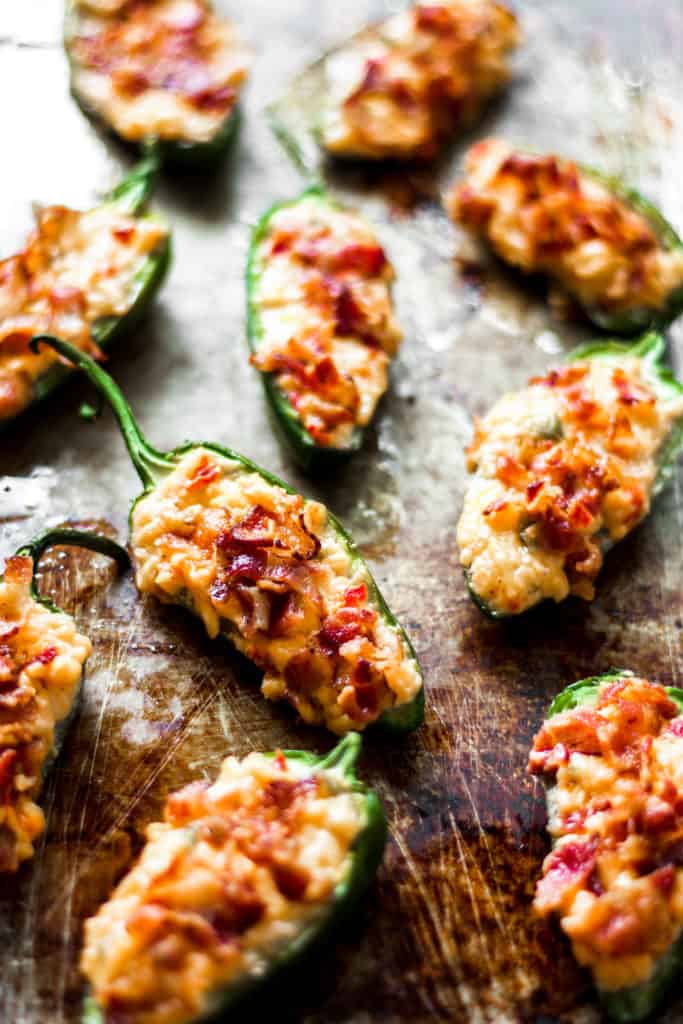 pimento cheese stuffed jalapenos baked on a metal sheet tray