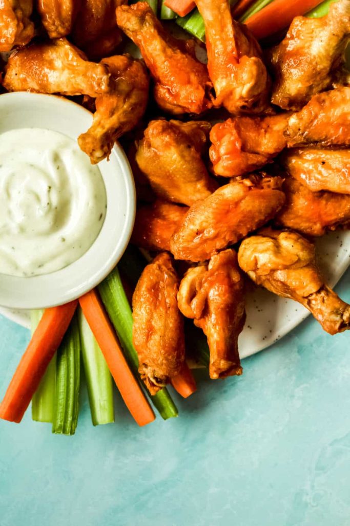 a pile of extra crispy air fryer chicken wings with a side of ranch dressing