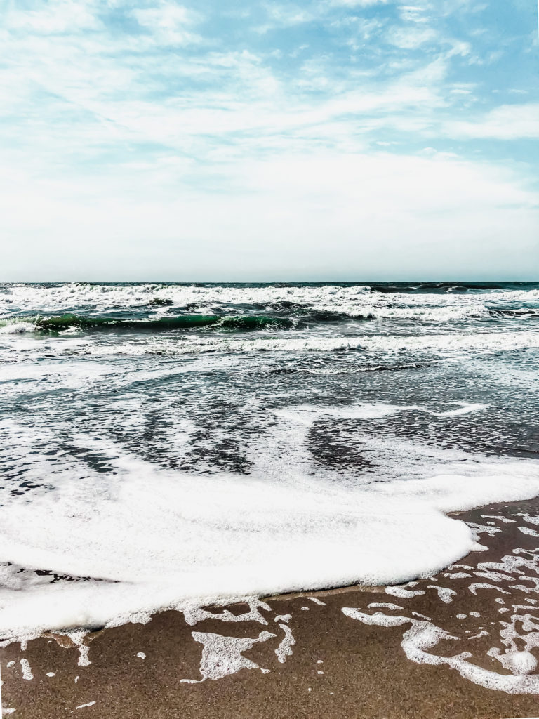 waves from the atlantic ocean crash on the beach in north carolina