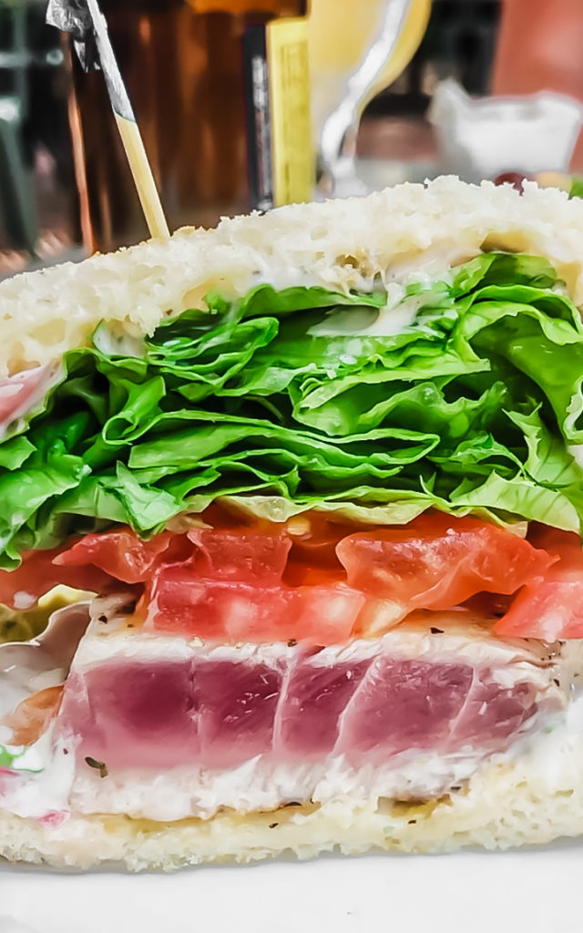 fish sandwich topped with tomato and lettuce at beaufort grocery company