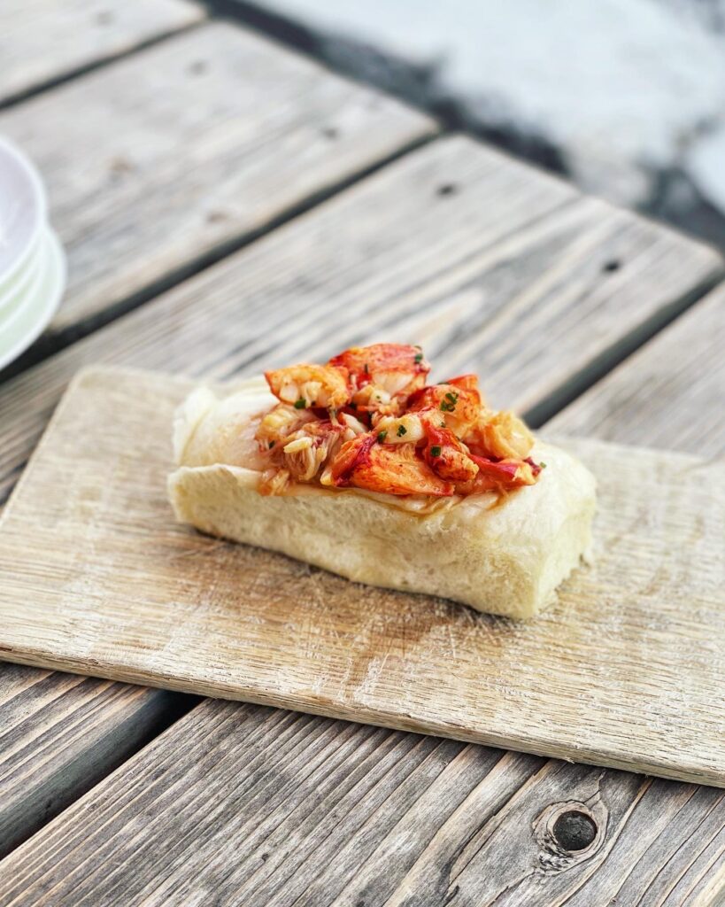 lobster roll on a wooden platter at a maine restaurant