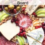 A charcuterie board with sliced meats, assorted cheeses, apple slices, nuts, orange segments, cranberries, olives, and rosemary—a delicious spread showing how to make a charcuterie board. Text overlay: How to Make the Perfect Charcuterie Board.