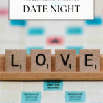 A Scrabble board with wooden tiles spelling LOVE in the rack. Text above reads The Best Fun Board Games for Couples for Date Night. The website offtheeatenpathblog.com is at the bottom.