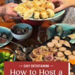 Two people serve bread and prepare food at a table set with vegetables, sausage, cheese, and a raclette grill. Text overlay reads: Easy Entertaining: How to Host a Raclette Dinner Party.