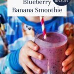 A child in a colorful shirt holds a glass of blueberry banana smoothie with a red and white striped straw. The text reads, Blueberry Banana Smoothie - Inspired by Heated Rivalry.