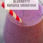 A glass of blueberry banana smoothie with a red and white striped straw. The light purple blueberry banana smoothie shines, topped by a text overlay: Inspired by heated rivalry—Blueberry Banana Smoothie.