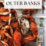Cooked crabs seasoned with spices are spread over newspaper beside a wooden mallet. Text overlay reads, Where to eat in the Outer Banks, highlighting top Outer Banks restaurants, with offtheeatenpathblog.com at the bottom.
