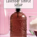 A decorative glass bottle filled with lavender simple syrup sits on a pink surface, surrounded by sugar, a glass of water, and lavender buds. Text reads: Easy Recipe Lavender Simple Syrup..